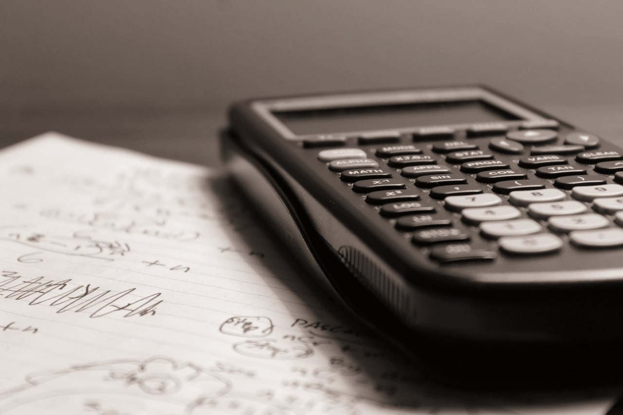 Calculadora sobre folhas com anotações à mão