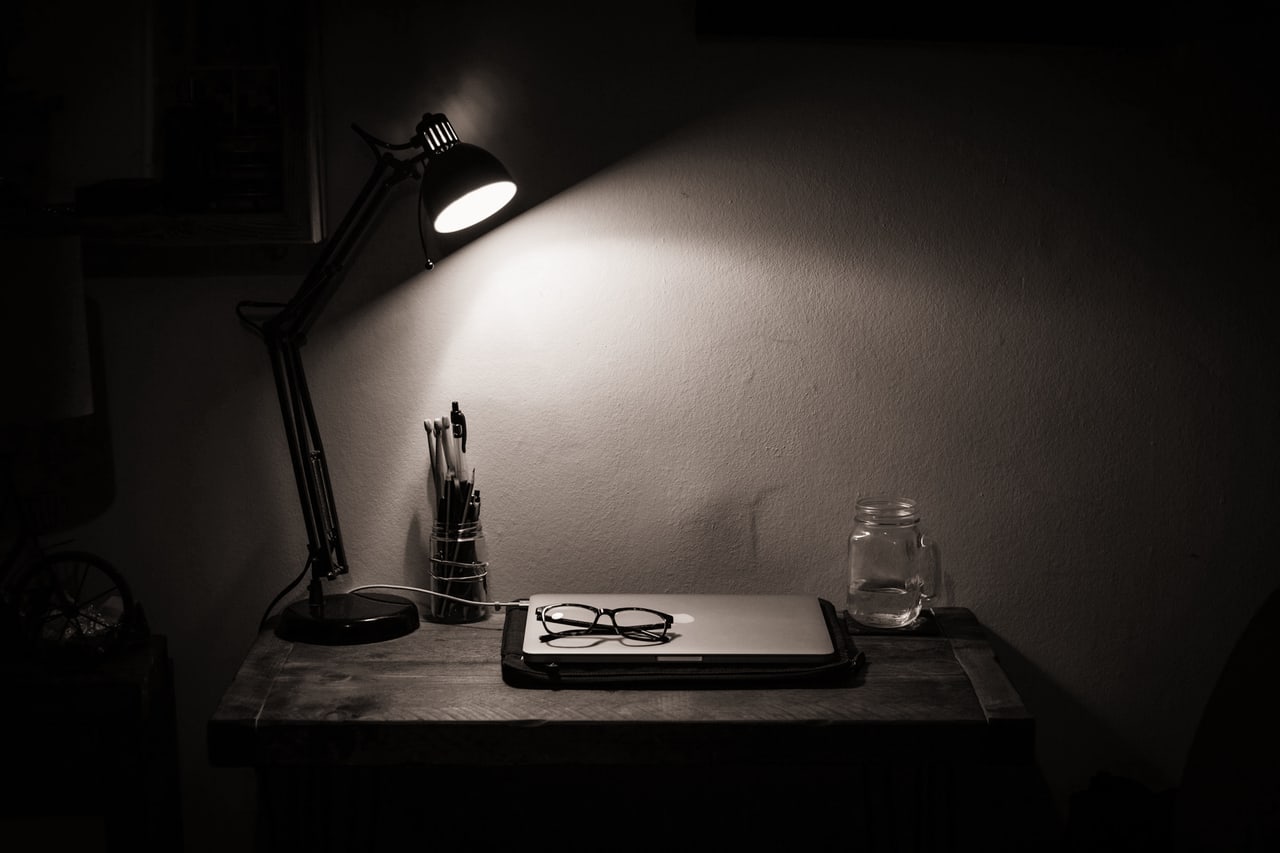 Luminária acesa sobre uma mesa, à noite